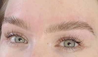 Brows and lashes of a fair-skinned client with green eyes, laminated brows